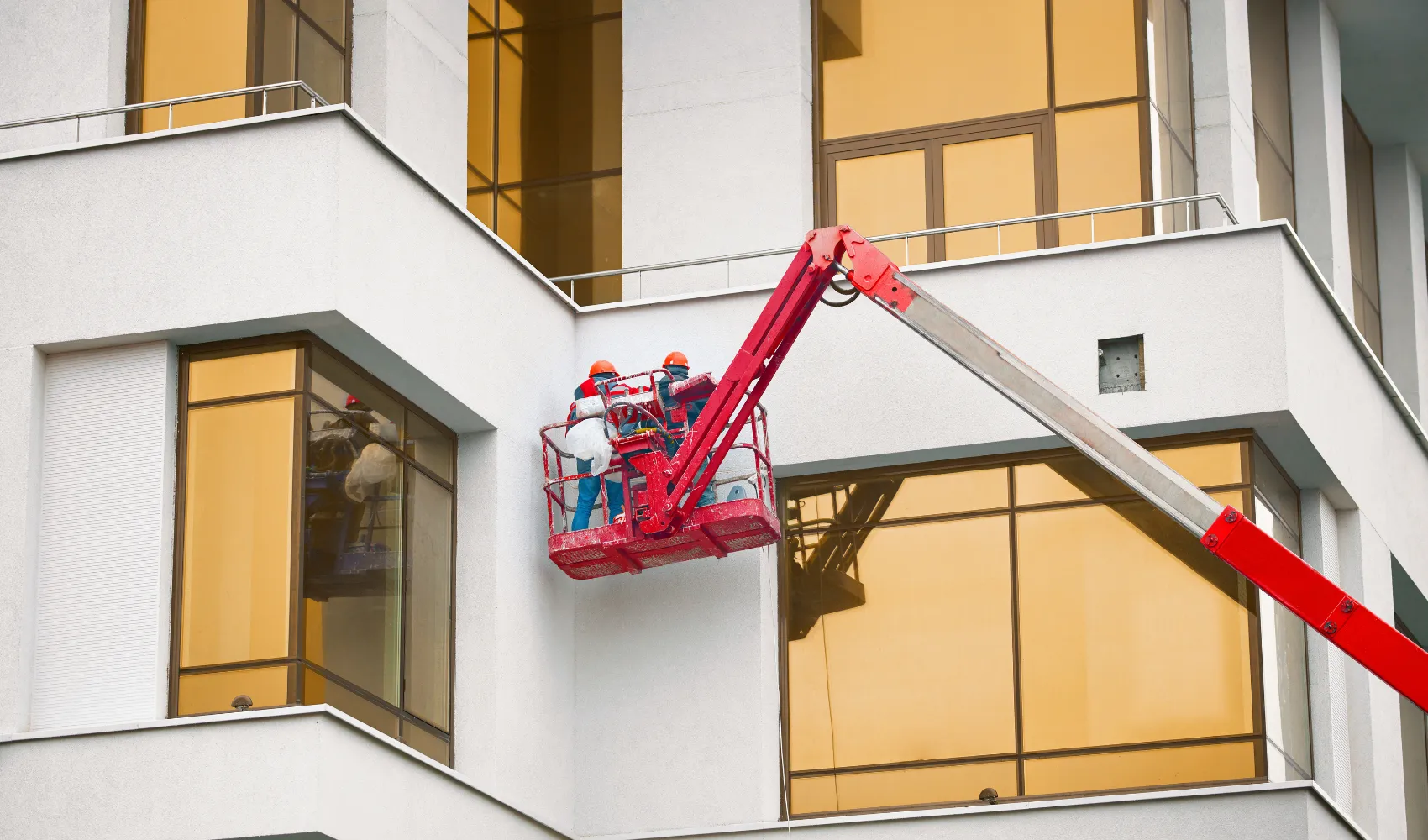 Professional commercial exterior painting using lift equipment on modern office building in Los Angeles