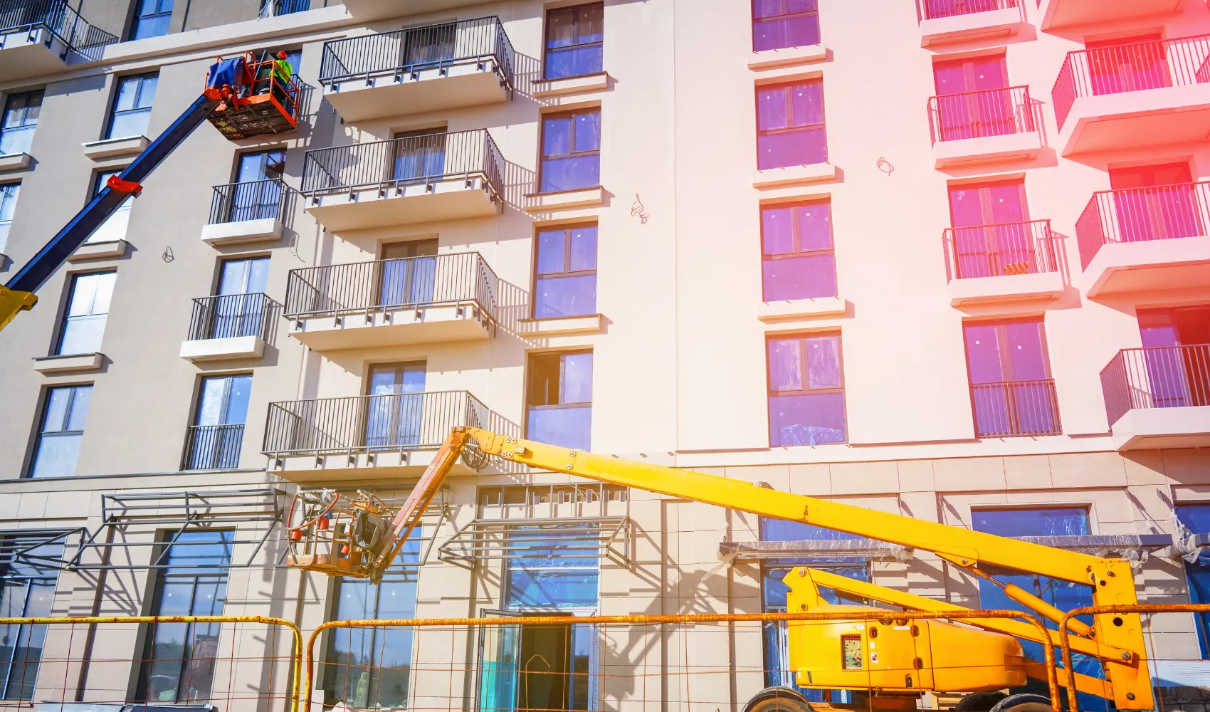 Professional HOA exterior painting of apartment balconies using boom lift equipment in Los Angeles California