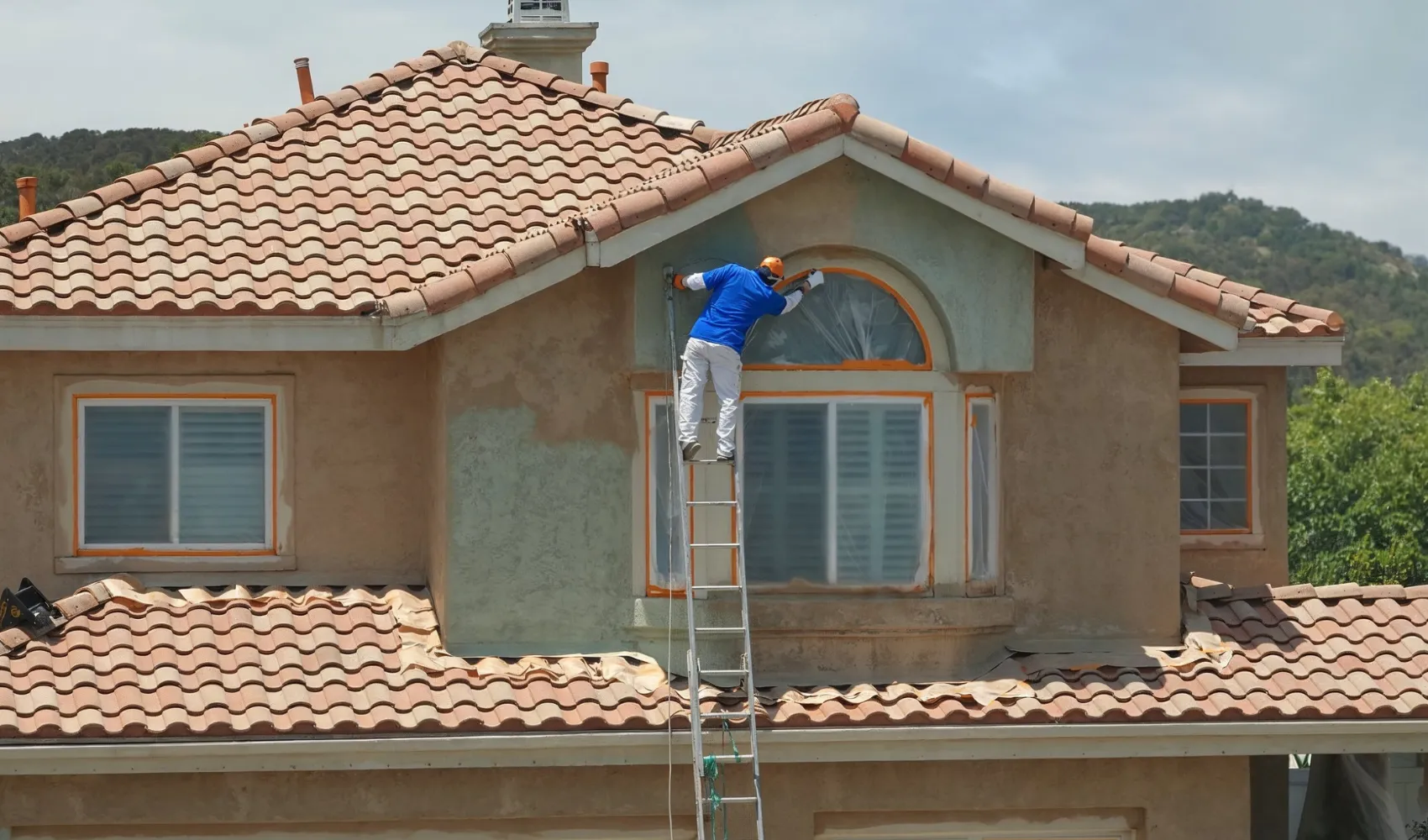 Residential interior painting service using roller to apply smooth, even wall paint finish