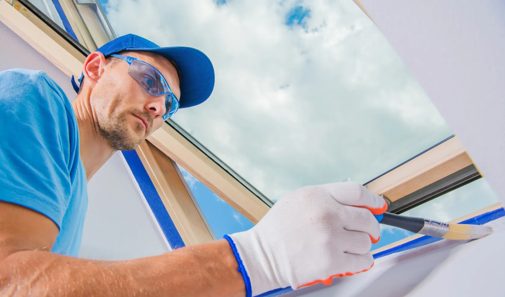 Residential interior painting service showing professional painter detailing window trim with precision